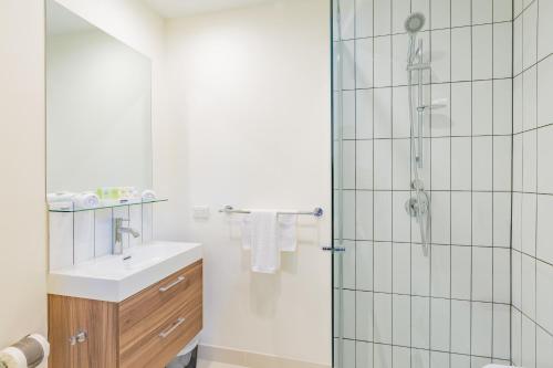 a bathroom with a shower and a sink at City Edge Box Hill Apartment Hotel in Box Hill