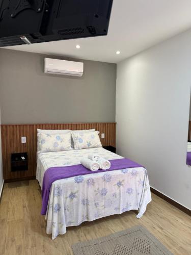 a bedroom with a bed with two towels on it at Suítes Refúgio in Abraão
