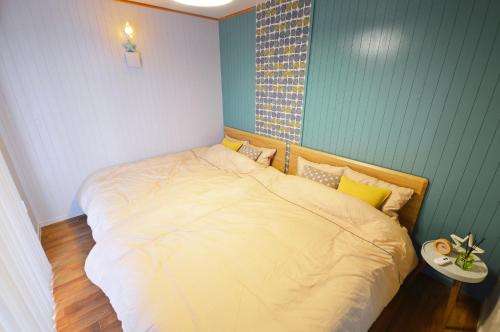 a bedroom with a large bed with yellow pillows at I will meet Hyakuna, - Vacation STAY 33599v in Nanjo
