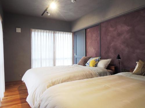 a bedroom with two beds and a window at I will meet Nesabu, - Vacation STAY 33801v in Tomigusuku