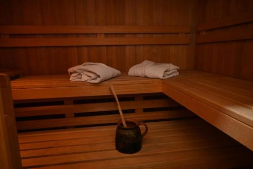 a sauna with two towels and a bucket in it at A Frame Vila sa Saunom Jakuzi kadom i toplim bazenom in Koraćica