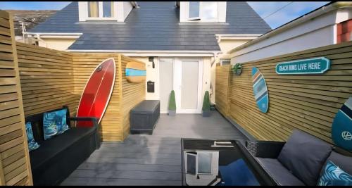 a house with a deck with a surfboard on it at Perran Beach House in Perranporth