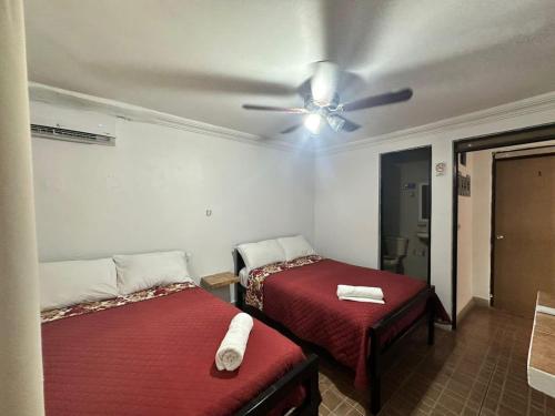 a bedroom with two beds and a ceiling fan at Hotel Miranda in La Concepción