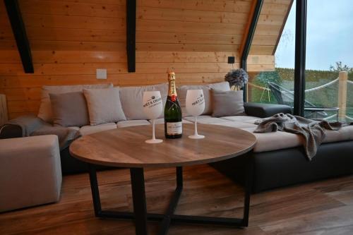a bottle of wine on a table in a living room at A Frame Vila sa Saunom Jakuzii i toplim bazenom in Koraćica