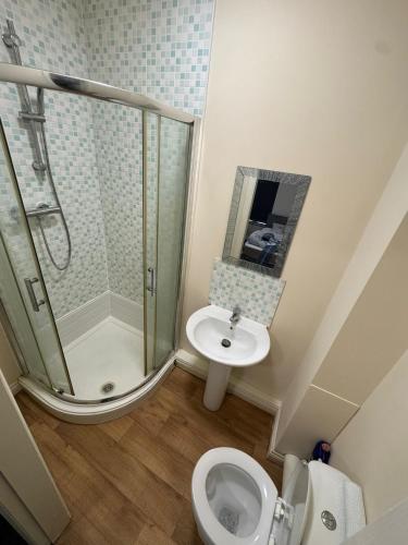 a bathroom with a shower and a toilet and a sink at Barnsley Guesthouse Couple Room Ground Floor in Barnsley