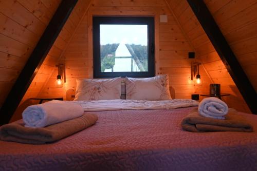a bedroom with a large bed with towels on it at A Frame Vila sa Saunom Jakuzii i toplim bazenom in Koraćica