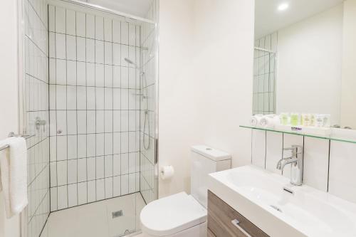 a bathroom with a toilet sink and a shower at Comfort Apartments Box Hill in Box Hill