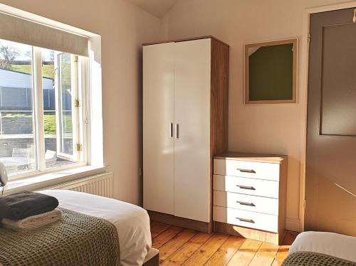 a bedroom with a bed and a cabinet and a window at 3 Bed in Aberaeron 95971 in Aberaeron