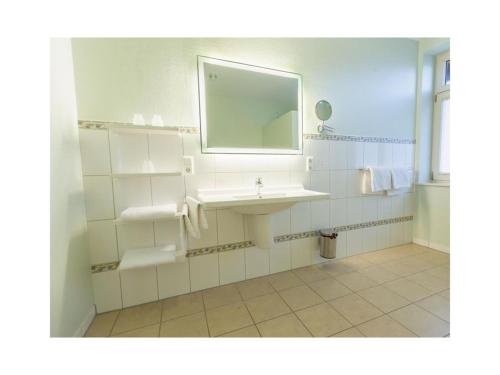 een badkamer met een wastafel en een spiegel bij Suurhusen - Greetsiel in Greetsiel