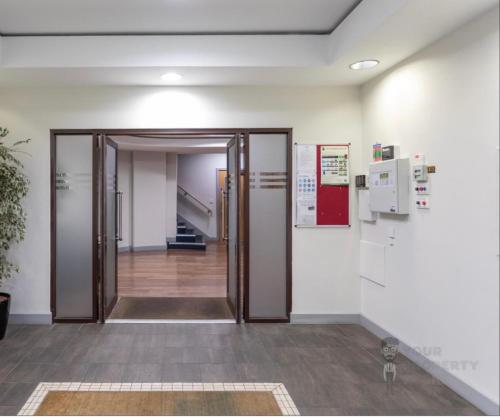 un couloir avec une porte ouverte dans un bâtiment dans l'établissement New 4 stars Large prime city center 2 bed 2 bath duplex apartment with free secure parking, à Belfast