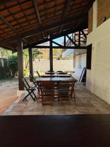 a large wooden table and chairs on a patio at Kaza Cumbuco Hostel in Caucaia