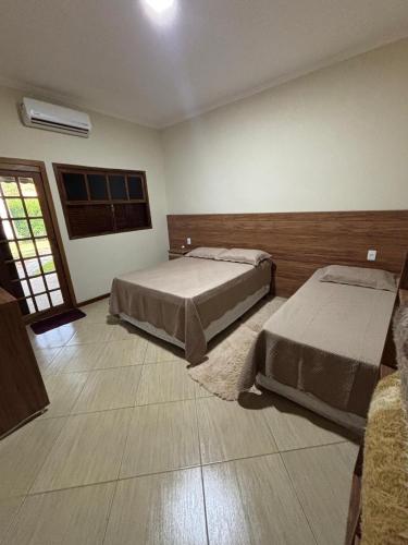 a bedroom with two beds and a window at Recanto Vale Minã in Lavrinhas