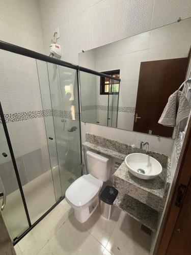 a bathroom with a toilet and a sink and a shower at Recanto Vale Minã in Lavrinhas