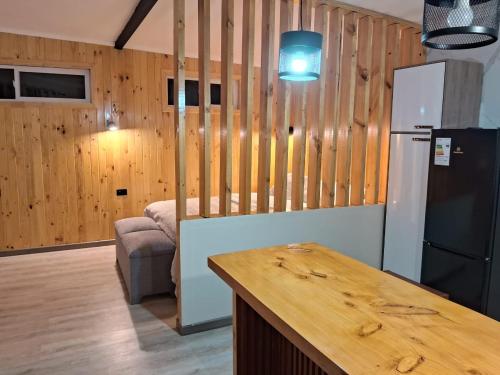 a kitchen with wooden walls and a refrigerator and a table at Tiny House Ruta 215 in Osorno