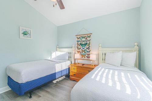 two beds in a room with blue walls and wooden floors at Coastal Pet Friendly Getaway in Murrels Inlet! Perfect for 8 Guests! in Myrtle Beach