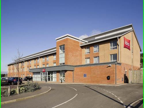 a large red brick building with a sign on it at ibis Swansea in Swansea