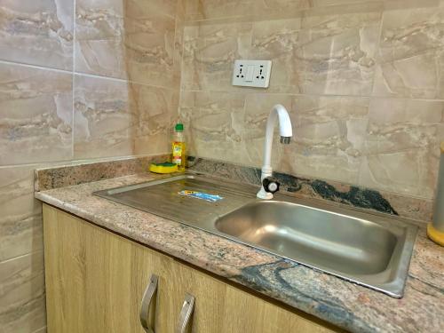 a sink in a kitchen with a counter top at Cozy Corners in Iseri-Oke