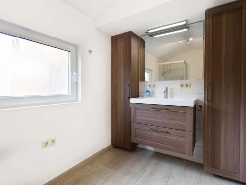 un baño con lavabo y espejo en Holiday home with 3 bedrooms, en Norddeich