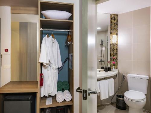 y baño con lavabo, aseo y toallas. en ibis Samui Bophut Hotel, en Bophut 