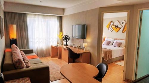 a hotel room with a bedroom with a bed and a desk at Hotel aeroporto Guarulhos in Guarulhos