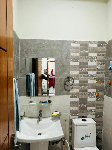 a bathroom with a sink and a toilet and a mirror at Flat in wah cantt in Wāh