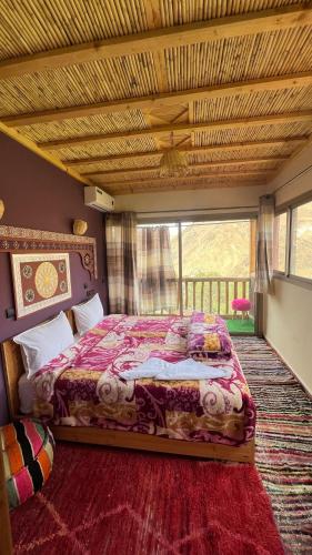 a bedroom with a bed and a large window at Gite Panorama in Imlil