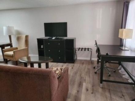 a living room with a couch and a tv and a table at The Lake Huron Resort in Oscoda