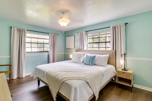 a bedroom with a bed with blue walls and windows at Bring Your Boat! Canal-Front Tavares Home with Dock in Tavares