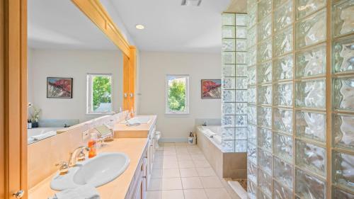 a bathroom with two sinks and a tub and a shower at Vineyard Estate w Pool Spa Bocce Ball Mins to Wineries Park Lawndale Road by AvantStay in Lawndale