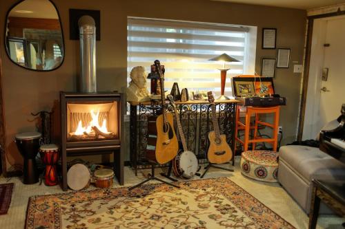 ギブソンズにあるSEAS THE DAY house hot tub pet friendly bbq location location locationのギターと暖炉が置かれたリビングルーム