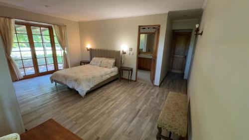 Un dormitorio con una cama en una habitación con suelo de madera. en Countryside Retreat, en Peralillo