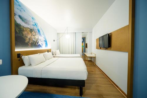 a hotel room with a bed and a tv at Hotel Euro Suite Curitiba Batel By Nacional Inn in Curitiba