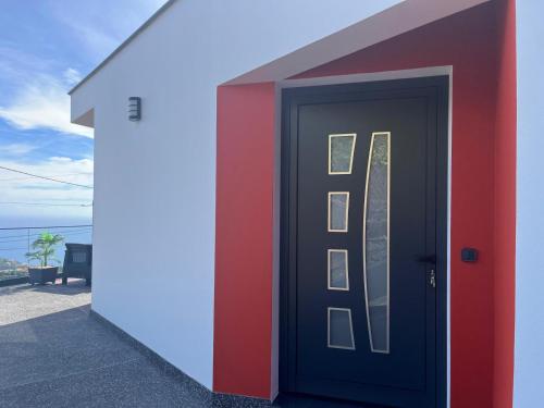 a door to a building with the ocean in the background at Villa Bacana Oasis in Estreito da Calheta