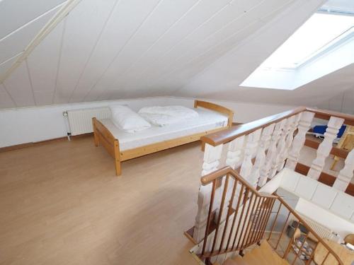 a attic room with a bed and a staircase at 1-bedroom holiday home in Dorum Neufeld