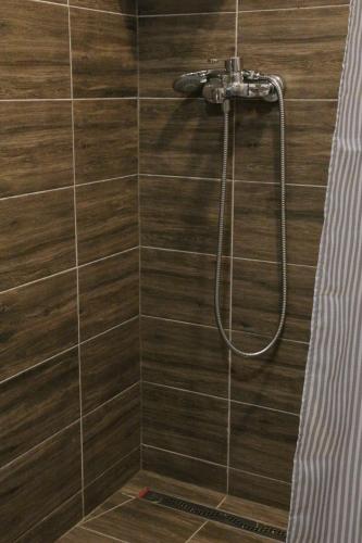 a bathroom with a shower with wooden tiles at The Rest Nest in Risovac