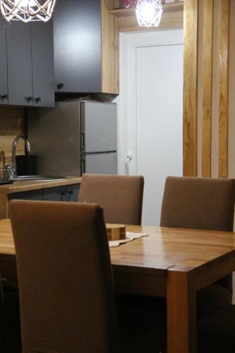 eine Küche mit einem Tisch mit Stühlen und einem Kühlschrank in der Unterkunft The Rest Nest in Risovac