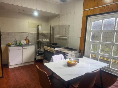 a kitchen with a table and a counter top at Casa España in Punta Arenas