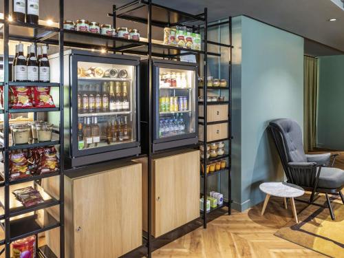 a bar with an open refrigerator and a chair at Aparthotel Adagio Porte de Versailles in Issy-les-Moulineaux