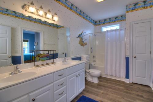 Un baño con dos lavabos y una ducha y un inodoro. en Stairway to Havens - South, en Myrtle Beach