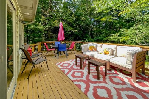 a deck with a couch and chairs and a table at Betsie Woods in Thompsonville