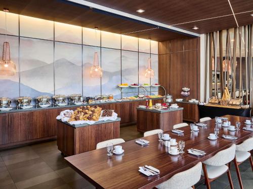 a restaurant with wooden tables and chairs and a buffet at Novotel Toronto Vaughan Centre in Vaughan