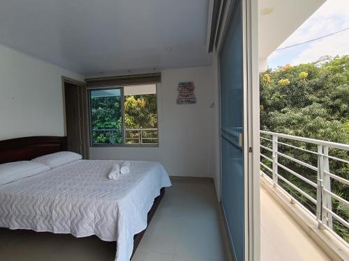 a bedroom with a bed and a balcony at centrico Apartamento con piscina Anapoima in Anapoima