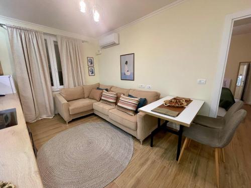 ein Wohnzimmer mit Sofa und Tisch in der Unterkunft al centro apartment in Shkodra