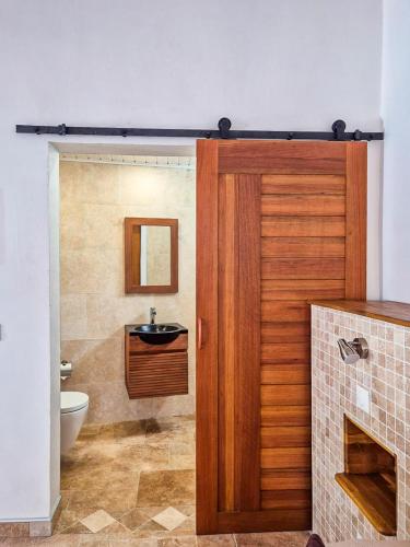 a bathroom with a wooden door and a sink at Chez didine in Terre-de-Haut