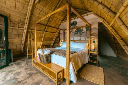 a bedroom with a canopy bed in a wooden room at Hotel Casa Selvaggio in Ráquira