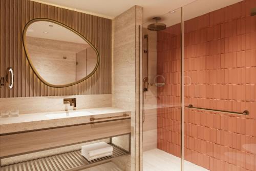a bathroom with a shower and a sink and a mirror at Delta Hotels by Marriott Istanbul Karakoy in Istanbul