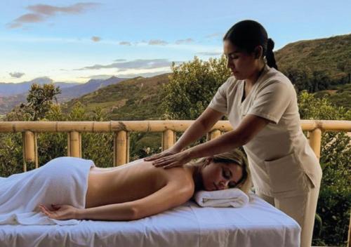 a woman is helping a woman on a bed at Hotel Casa Selvaggio in Ráquira