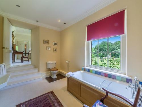 a bathroom with a tub and a large window at 9 Bed in Ingoldisthorpe KT095 in Ingoldisthorpe