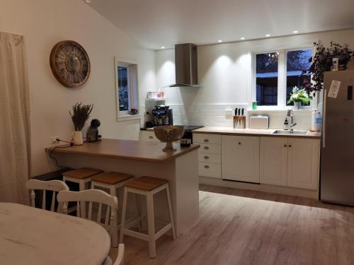 a kitchen with white cabinets and a wooden table at Beautiful villa near everything! in Christchurch