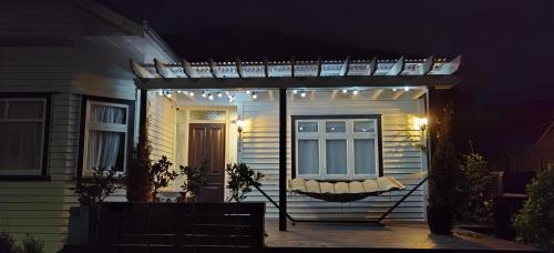 a pergola with lights on a house at night at Beautiful villa near everything! in Christchurch